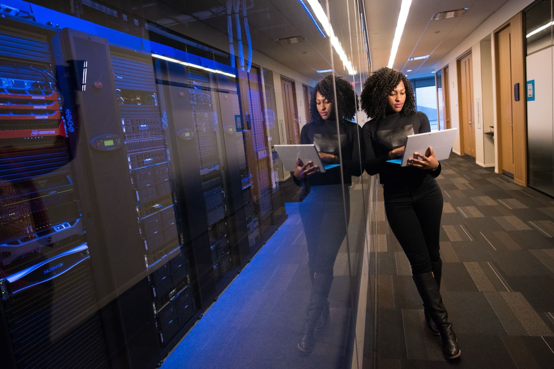 IT staff reviewing infrastructure on a tablet in a server room